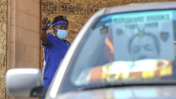 Vicki Lynn Buckley-Ameen with an image of Rayshard Brooks in her front windshield lamented what had happened at Wendy’ss as she watched the demolition on Tuesday, July 14, 2020. The Wendy’s where Rayshard Brooks was killed by Atlanta police last month was torn down. Construction crews used an excavator to demolish the charred remains of the University Avenue restaurant. JOHN SPINK/JSPINK@AJC.COM