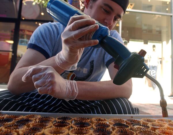  Nick Leahy, who previously served as the executive chef at Pacific Kitchen, torches caramel creme brule in 2006. / AJC file photo