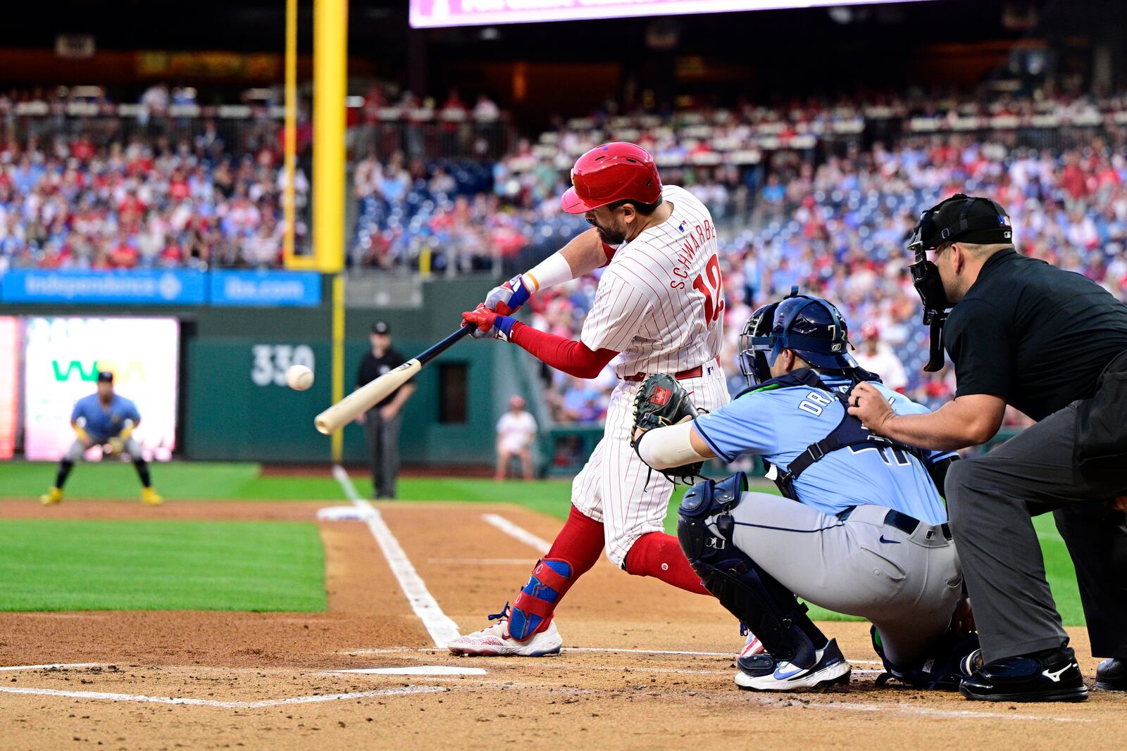 Philadelphia Phillies' Kyle Schwarber, center, hits a solo home run off Tampa Bay Rays' Taj Bradley during the first inning of a baseball game, Tuesday, Sept. 10, 2024, in Philadelphia. (AP Photo/Derik Hamilton)