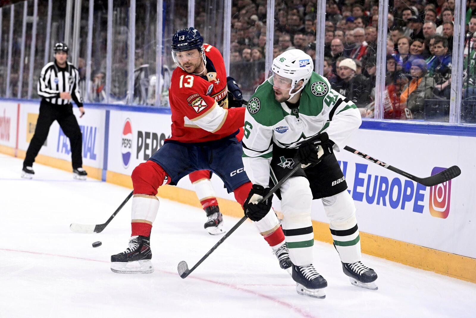 Florida Panthers' Sam Reinhart (13) and Dallas Stars' Ilya Lyubushkin (46) battle for the puck during an NHL hockey game, Saturday, Nov. 2, 2024, in Tampere, Finland. (Heikki Saukkomaa/Lehtikuva via AP)