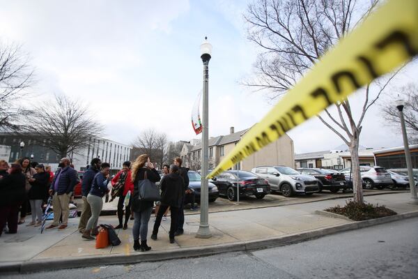 Workers from nearby businesses wait to get back to work Thursday afternoon after a suspicious package was discovered in downtown Decatur.