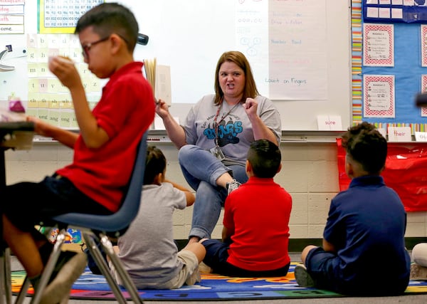 Third grade teacher Jennifer Boettcher reads a story to kids as they eat breakfast at San Marcos Elementary School Friday, May 4, 2018, in Chandler, Ariz., after a statewide teachers strike ended. The week of May 7-12 is National Teacher Appreciation Week.  (AP Photo/Matt York)