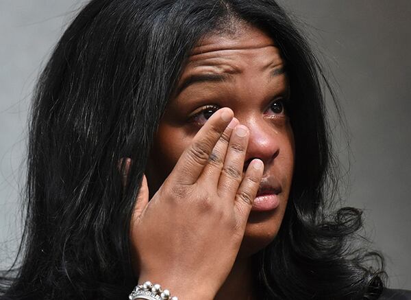 Ashley Smith wipes away tears as others talk about how she and others were mistreated recently at a Naperville, Ill. Buffalo Wild Wings restaurant.