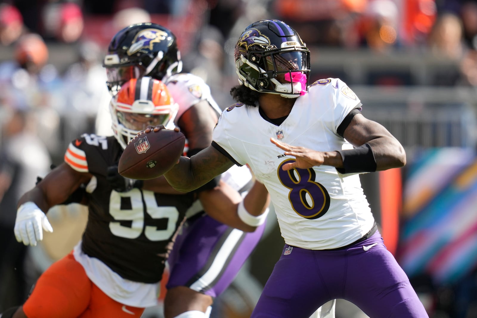 Baltimore Ravens quarterback Lamar Jackson (8) throws in from top Cleveland Browns defensive end Myles Garrett (95) during the first half of an NFL football game in Cleveland, Sunday, Oct. 27, 2024. (AP Photo/Sue Ogrocki)