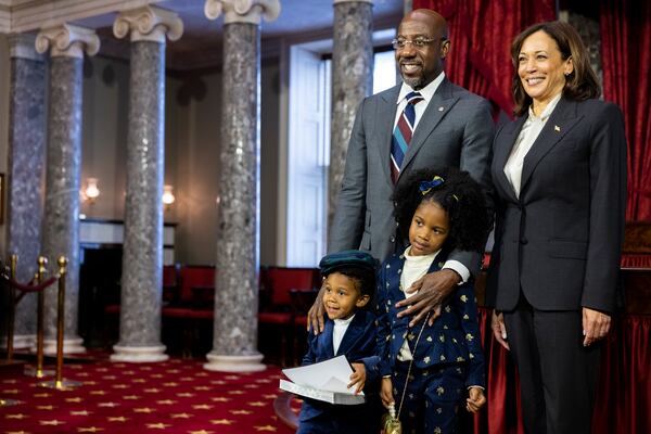 In this 2022 file photo, U.S. Sen. Raphael Warnock, D-Ga., and his two children are seen with Vice President Kamala Harris at the Capitol in Washington. Warnock is backing Harris for president.
