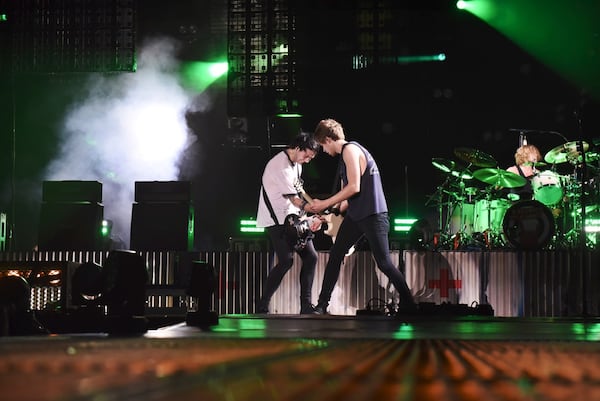 Michael Clifford and Luke Hemmings play each other's guitars. Photo: Kate Teegardin/Special to the AJC.