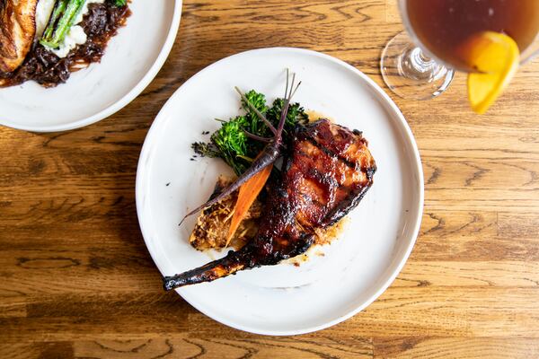 A-street Luxardo Adobo Glazed Pork Chop with au gratin potatoes and baby carrots. (Mia Yakel for The Atlanta Journal-Constitution)