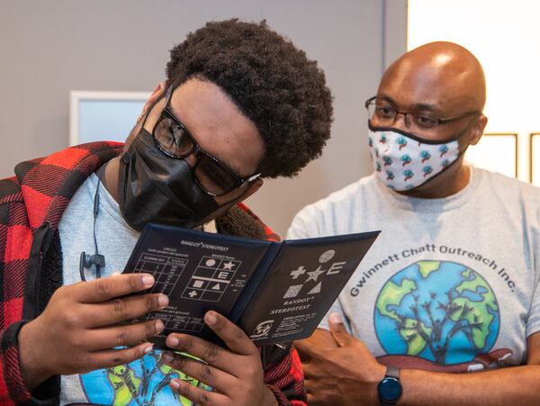 Paul Duke STEM High School student Kevin Freeman (left) struggles to see through special glasses while Ryan Cox watches at First Class Eye Care in Duluth. Ryan Cox founded the nonprofit Gwinnett Chatt Outreach last year that mostly donates food and other supplies and furthers community relations with the police. But one of its programs is called "Bridging the Gap," where he takes teenagers and young adults around to different businesses around Gwinnett County to show them different career opportunities. 
PHIL SKINNER FOR THE ATLANTA JOURNAL-CONSTITUTION.