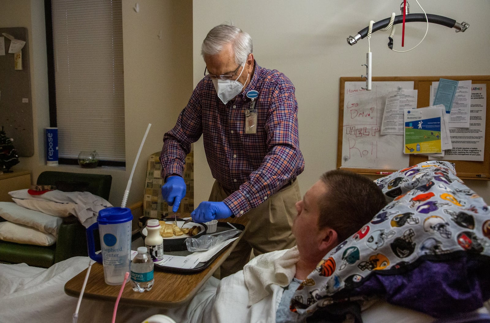 Volunteer Zach Wilson helps patient Dean Southworth with his breakfast at the Shepherd Center Monday morning, December 13, 2021.  STEVE SCHAEFER FOR THE ATLANTA JOURNAL-CONSTITUTION