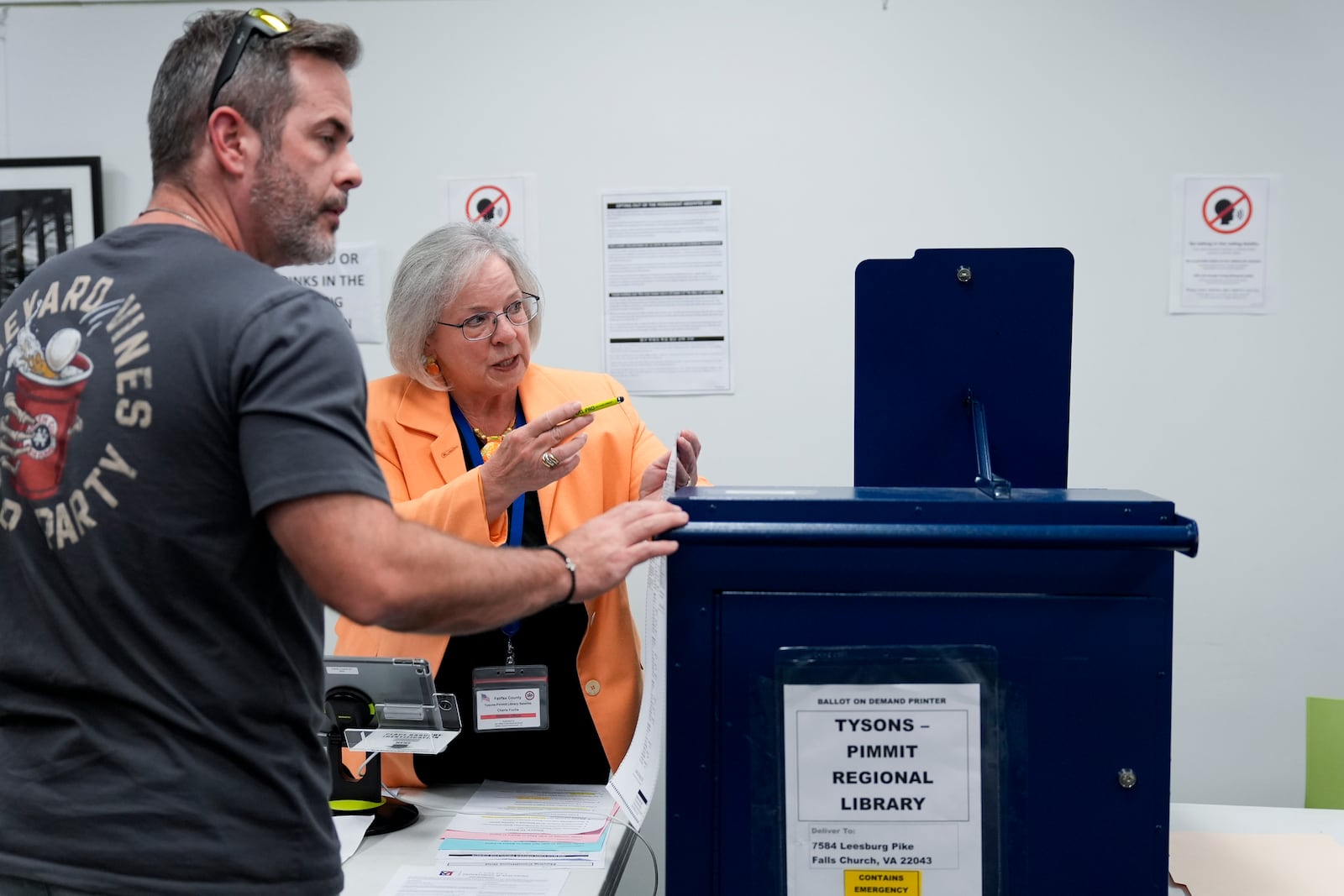 An election worker assists a voter at the polling place at Tysons-Pimmit Regional Library in Falls Church, Va., Thursday, Oct. 31, 2024. (AP Photo/Stephanie Scarbrough)