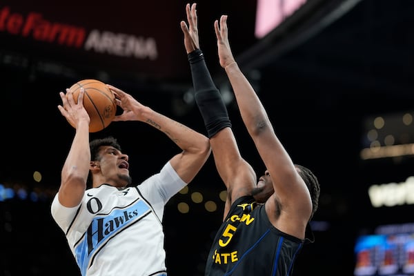 Atlanta Hawks forward Dominick Barlow (0) shoots against Golden State Warriors forward Kevon Looney (5) during the first half of an NBA basketball game, Saturday, March 22, 2025, in Atlanta. (AP Photo/Mike Stewart)