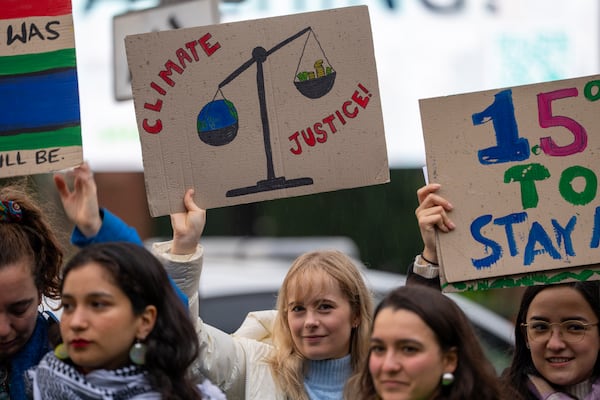 Activists protest outside the International Court of Justice, in The Hague, Netherlands, as it opens hearings into what countries worldwide are legally required to do to combat climate change and help vulnerable nations fight its devastating impact, Monday, Dec. 2, 2024. (AP Photo/Peter Dejong)