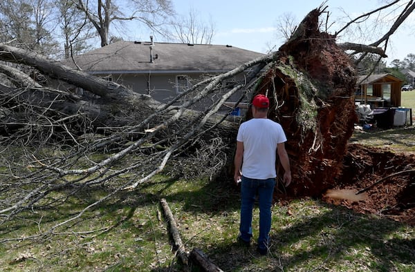 Clifford White, home owner, watches the fallen tree that damaged his house after a storm passed through, Sunday, March 16, 2025, in Dallas. National Weather Service teams will be conducting a damage survey in the Paulding County/Dallas area, which sustained “pretty significant” damage from the storms, NWS Senior Meteorologist Dylan Lusk told The Atlanta Journal-Constitution on Sunday morning. (Hyosub Shin / AJC)