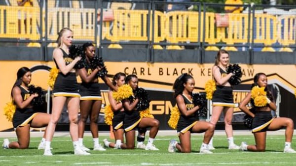 Some Kennesaw State University cheerleaders take a knee during the national anthem before the football game Sept. 30, to protest police misconduct and racial inequality. Cory Hancock / Special to the AJC