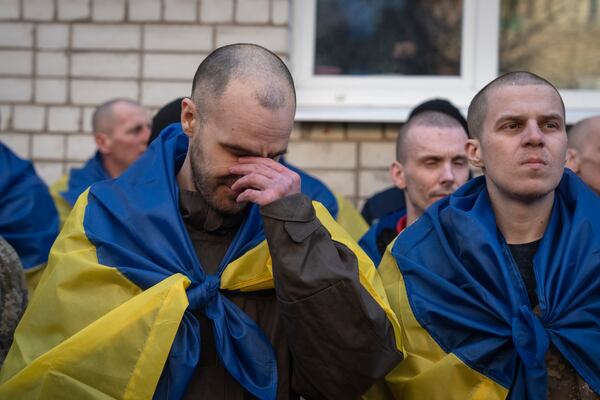 Ukrainian servicemen react after returning from captivity during a POWs exchange between Russia and Ukraine, in Chernyhiv region, Ukraine, Wednesday, March 19, 2025. (AP Photo/Efrem Lukatsky)