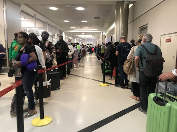 Travelers lined up on one side of an airport hallway for the North security checkpoint, while more lined up on the other side of the hallway for Southwest check-in and baggage check.