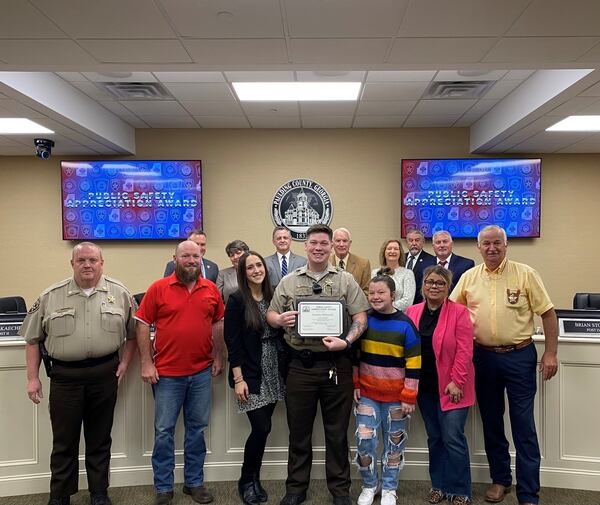 Paulding County Deputy Zackery Dubreuiel (center) was recognized at a county commission meeting for saving a child's life.