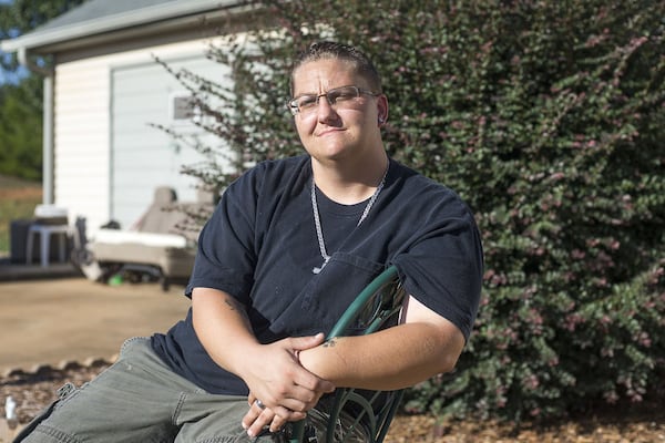 On her release from Henry County’s jail, Tiffany Callahan was issued a pre-paid debit card holding the money she went in with. The cards charge fees for transactions. ‘I don’t agree with the fees,’ says Callahan. ‘It’s my money that I saved up.’ Callahan sits outside her home in Locust Grove. ALYSSA POINTER / ALYSSA.POINTER@AJC.COM