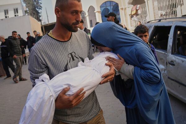 Nasma Al-Saifi kisses the wrapped body of her nephew, Khaled, who was killed during an Israeli army strike, before his burial at the Baptist Hospital in Gaza City, Monday, March 24, 2025. (AP Photo/Jehad Alshrafi)