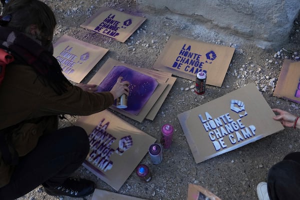 An activist prepares posters before a women's rights demonstration Saturday, Dec. 14, 2024 in Avignon, southern France, where the trial of dozens of men accused of raping Gisèle Pelicot while she was drugged and rendered unconscious by her husband is taking place. (AP Photo/Aurelien Morissard)