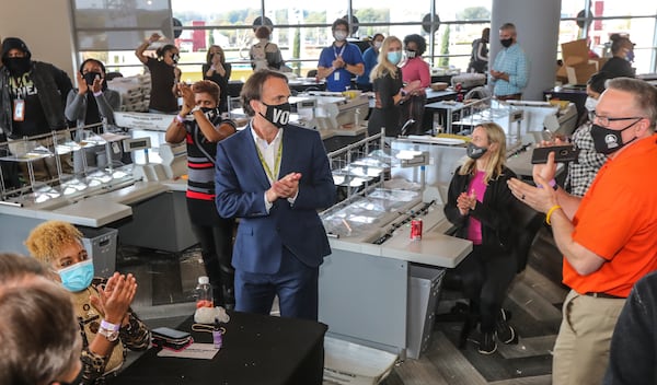 Fulton elections head Richard Barron is applauded by workers on Thursday, Nov. 5, 2020 counting ballots at State Farm Arena. Fulton County officials say election workers have completed processing absentee-by-mail ballots. (John Spink / John.Spink@ajc.com)

