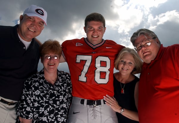 UGA lineman Jon Stinchcomb with his parents from left, Gary and Estelle Stinchcomb and Karen and J.R. Johnson on Aug. 17, 2002 in Athens. Though his birth parents Gary and Karen are divorced, they are still friends and are very supportive of Jon. Both sets of his parents often tailgate together before games. (Brant Sanderlin/AJC file photo)