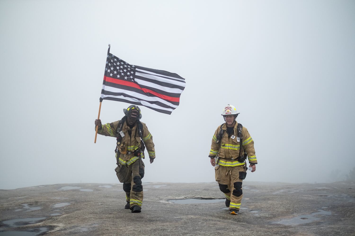 Morrow Firefighter Chad Gould (left) and Deputy Chief Jeff Moss crest Stone Mountain on Sunday morning, Sept. 11, 2022, during the annual remembrance of the 9/11 terrorist attacks. (Photo: Ben Gray for The Atlanta Journal-Constitution)