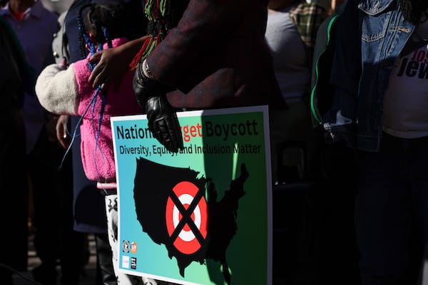 FILE - A community member holds a sign calling for a national boycott of Target stores during a news conference outside Target Corporation's headquarters Thursday, Jan. 30, 2025, in Minneapolis, Minn. (AP Photo/Ellen Schmidt, File)