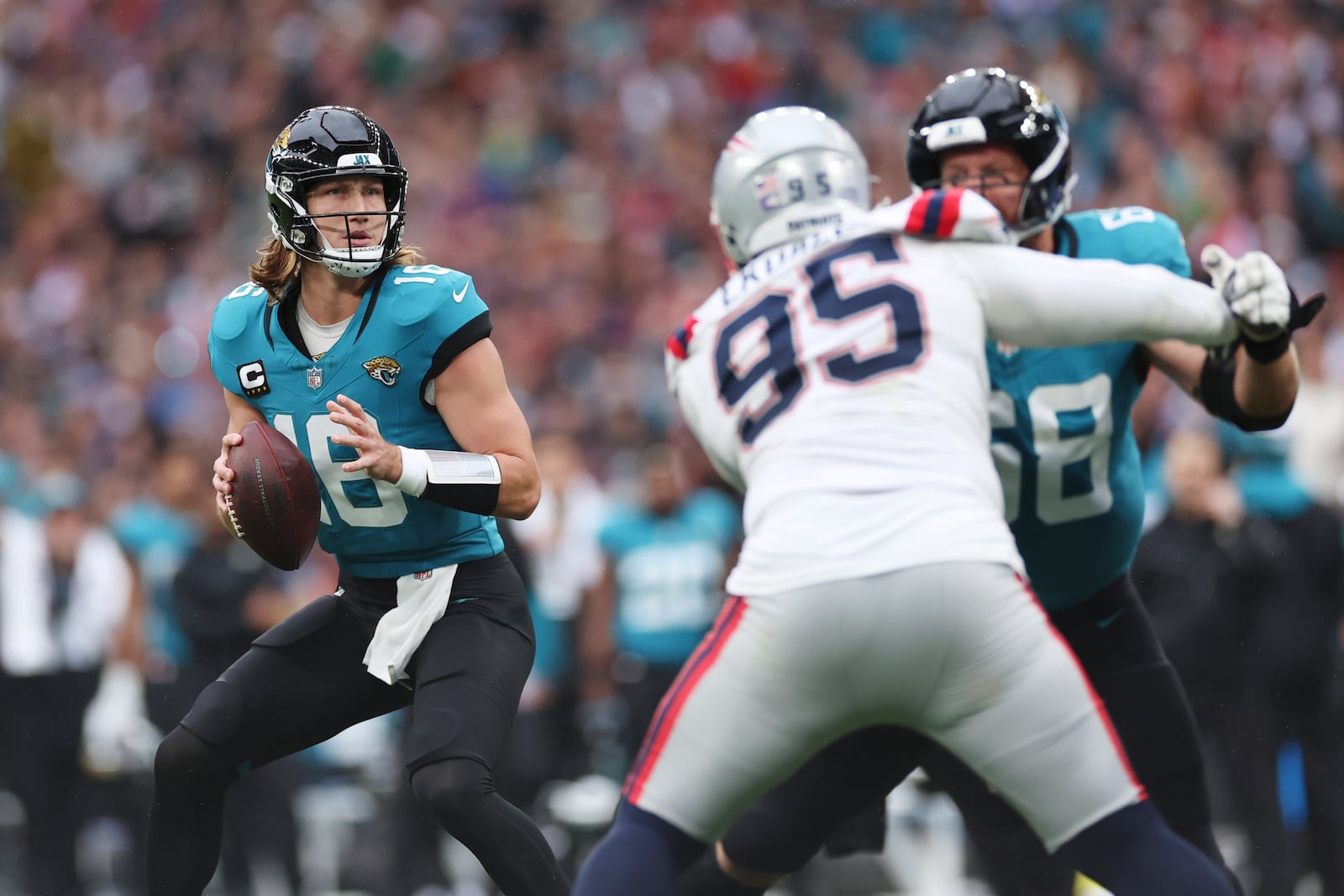 Jacksonville Jaguars quarterback Trevor Lawrence looks for a receiver during the first half of an NFL football game against the New England Patriots, Sunday, Oct. 20, 2024, in London. (AP Photo/Ian Walton)