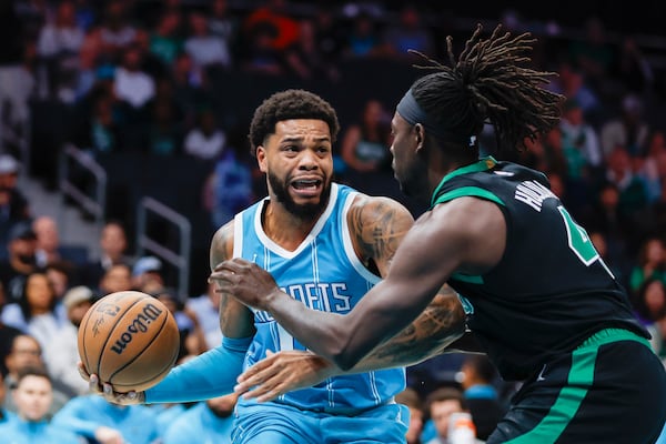 Charlotte Hornets forward Miles Bridges, left, drives against Boston Celtics guard Jrue Holiday during the first quarter of an NBA basketball game in Charlotte, N.C., Friday, Nov. 1, 2024. (AP Photo/Nell Redmond)