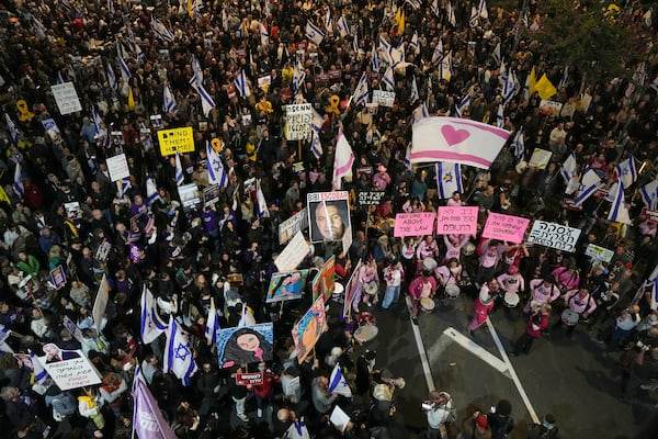 Israelis protest against Prime Minister Benjamin Netanyahu's government and call for the release of hostages held in the Gaza Strip by the Hamas militant group, in Tel Aviv, Israel, Saturday, Dec. 14, 2024. (AP Photo/Tsafrir Abayov)