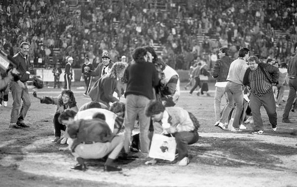 Fans take pieces of the turf. Photo by Billy Downs / AJC