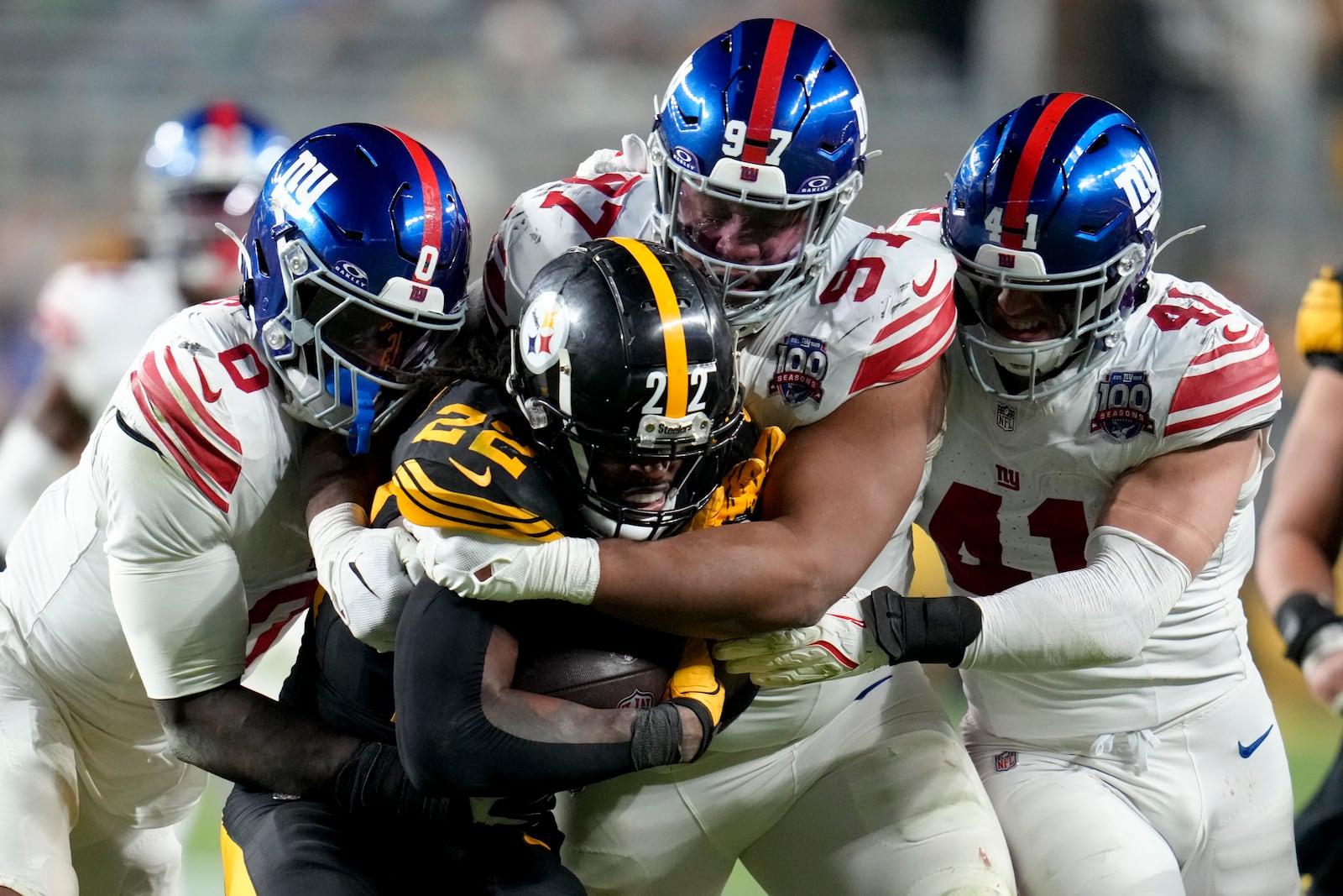 Pittsburgh Steelers running back Najee Harris (22) is tackled by New York Giants linebacker Brian Burns (0) defensive tackle Dexter Lawrence II (97) and linebacker Micah McFadden (41) during the second half of an NFL football game Monday, Oct. 28, 2024, in Pittsburgh. (AP Photo/Gene J. Puskar)