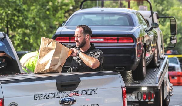 A black Dodge Challenger was towed from the fatal shooting scene at a Peachtree City CVS.