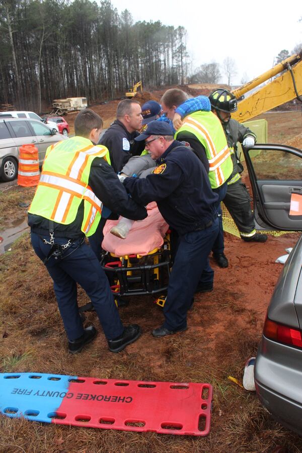 Cherokee County fire rescue workers load a 75-year-old woman onto a stretcher after she was trapped in her car. (Credit: Cherokee County Fire Rescue)