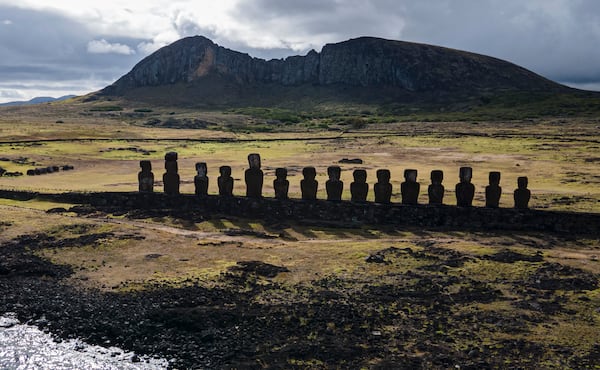 FILE - Moai statues stand on Ahu Tongariki near the Rano Raraku volcano, top, on Rapa Nui, or Easter Island, Chile, Nov. 27, 2022. (AP Photo/Esteban Felix, File)