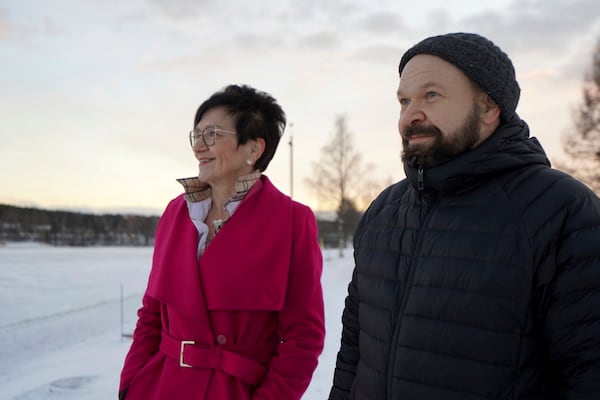 Antti Pakkanen, right, and Taina Torvela, members of a Rovaniemi housing network, stand by the Kemijoki River, in Rovaniemi, Finland, Wednesday, Dec. 4, 2024. (AP Photo/James Brooks)