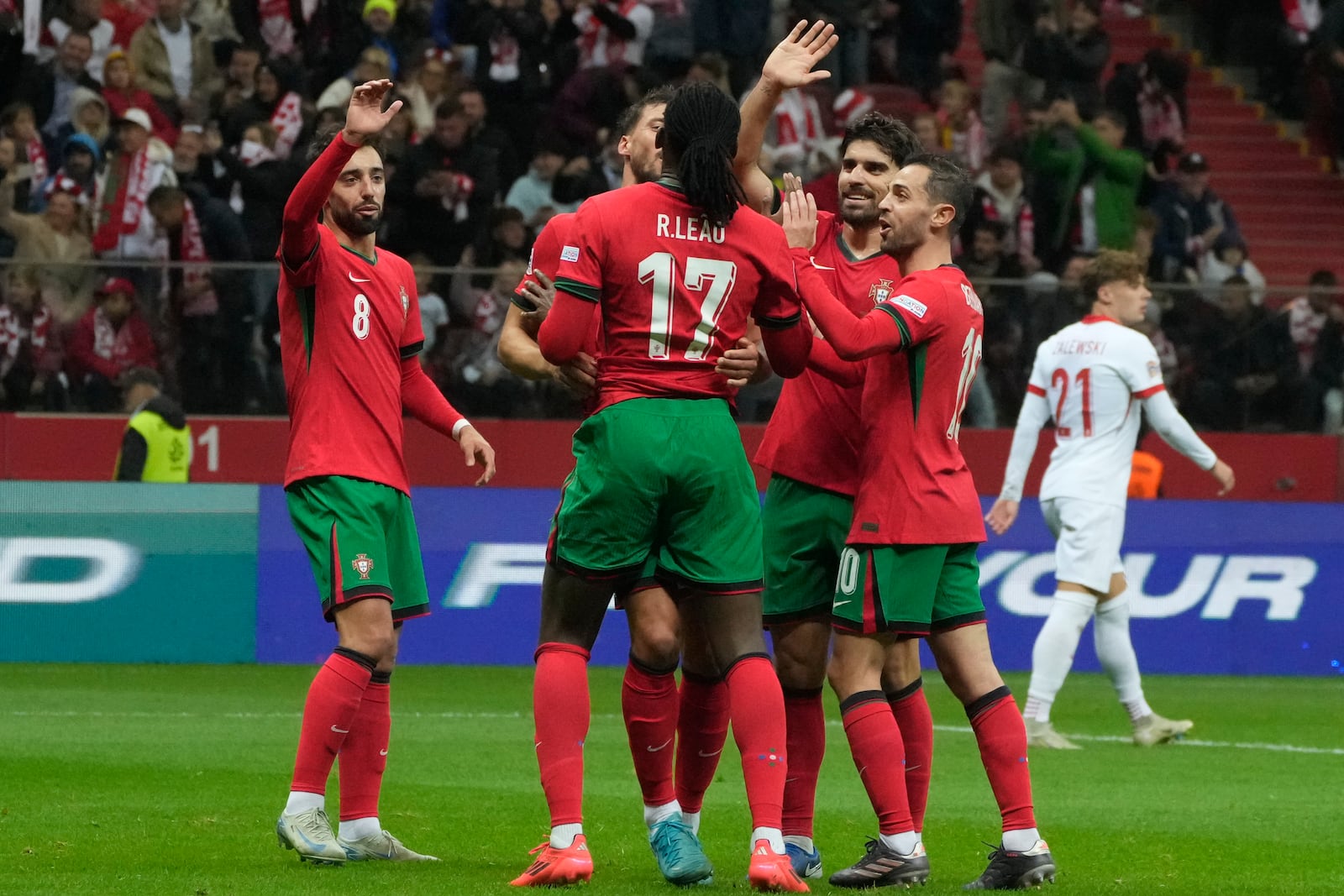 Portugal's Rafael Leao (17) is congratulated after assisting Cristiano Ronaldo for his side's second goal during the UEFA Nations League soccer match between Poland and Portugal at Narodowy stadium in Warsaw, Poland, Saturday, Oct. 12, 2024. (AP Photo/Czarek Sokolowski)