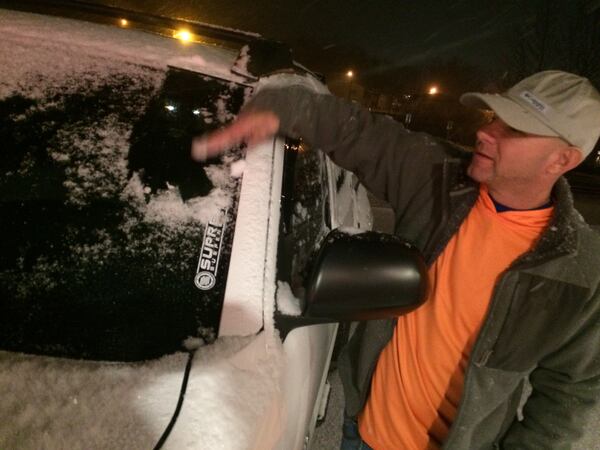 Nick McClure cleans his windshield Friday night after leaving Masseria restaurant in Blue Ridge. CRAIG SCHNEIDER / CSCHNEIDER@AJC.COM