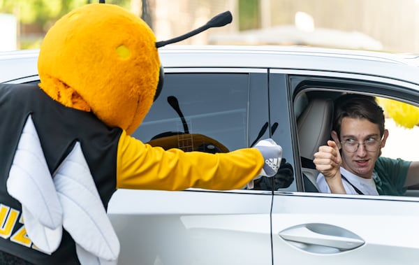 Jack Rumpf, an incoming first-year from Athens, fist-bumps Buzz, Georgia Tech’s mascot, while entering the Campus Recreation Center Parking Deck to check in for move-in on Georgia Tech's campus in Atlanta on Saturday, August 10, 2024. (Seeger Gray / AJC)