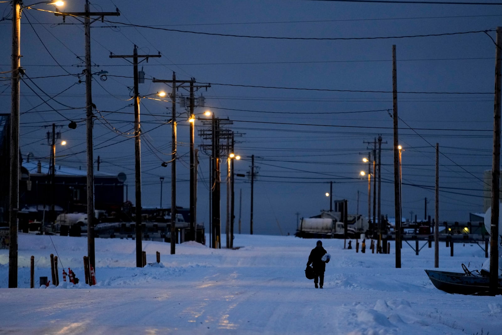 A villager walks through the snow in Kaktovik, Alaska, Monday, Oct. 14, 2024. (AP Photo/Lindsey Wasson)