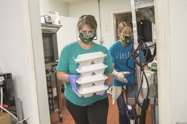 04/21/2020 - Smyrna, Georgia - Charity’s Vittles restaurant owner Charity Salyers (left) gets help from server Stacy Wingard (right) as they prepare to bag a customer’s meal at her restaurant in Smyrna, Tuesday, April 21, 2020. (ALYSSA POINTER / ALYSSA.POINTER@AJC.COM)