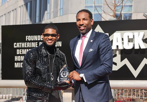 (Left to right) Recording artist Usher receives the Phoenix Award from Mayor Andre Dickens at The Black Music Walk of Fame in Atlanta on Wednesday, Feb. 14, 2024. (Natrice Miller/ Natrice.miller@ajc.com)