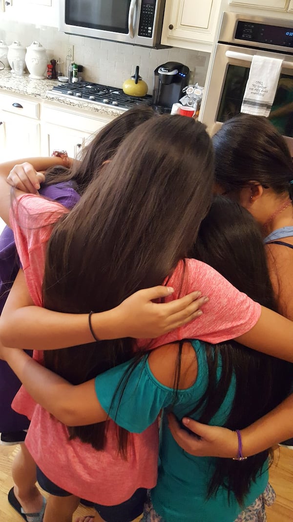 Emily Grace, Dora, Anna Claire, Eliana and Cate have a group hug before saying goodbye recently after a weekend in Alpharetta, where Emily Grace lives with her adoptive parents. The girls, now 11, were all adopted in China on the same day and meet every other year for a reunion. CONTRIBUTED