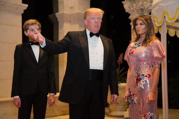 Barron Trump, left with his father, President Donald Trump and first lady Melania Trump walk the red carpet to the ballroom  for the Mar-a-Lago New Year's Eva Gala at Mar-a-Lago in Palm Beach, Sun., December 31, 2017  in Palm Beach, Fla. (Greg Lovett / The Palm Beach Post)