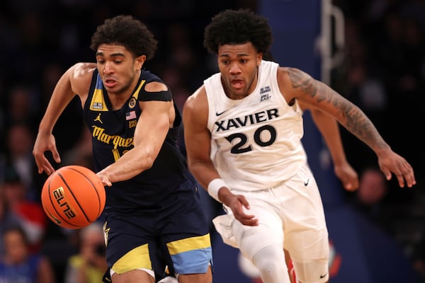 Marquette guard Stevie Mitchell, left, dribbles past Xavier guard Dayvlon McKnight (20) during the second half of an NCAA college basketball game in the quarterfinals of the Big East Conference tournament, Thursday, March 13, 2025, in New York. (AP Photo/Pamela Smith)