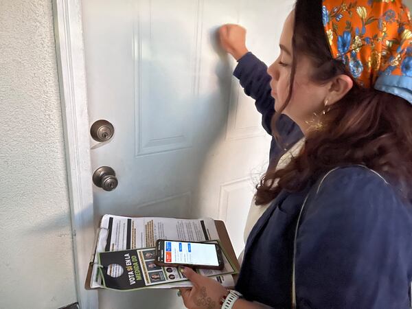 Tania Ortega, 27, knocks on the door of a Santa Ana, Calif. resident on Wednesday, Oct. 23, 2024, talk talk about Measure DD, which would allow noncitizens to vote in local elections. (AP Photo/Jaimie Ding)