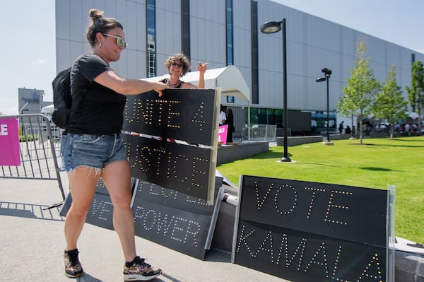 Sarah Cusick, a community supporter puts out slogans outside a Kamala Harris speech event at Georgia State Convention Center in Atlanta on Tuesday, July 30, 2024.  (Ziyu Julian Zhu / AJC)