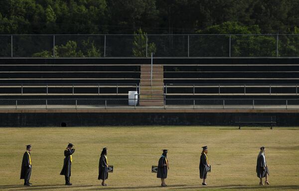 Graduating seniors in a line at Chattahoochee County High School on Friday, May 15, 2020, in Cusseta, Georgia. There were more than a hundred of them, and due to safety precautions they had to line up 10 at a time. With school restarting in August, educational leaders are considering their options, including a return to classrooms, full online instruction and a mix of online and in-person schooling. 