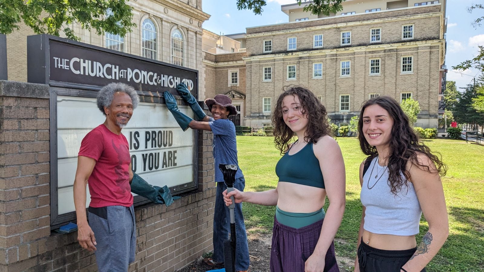 Neighbors help clean up the sign at The Church at Ponce and Highland. The sign was defaced and the church's Pride flag was ripped down.